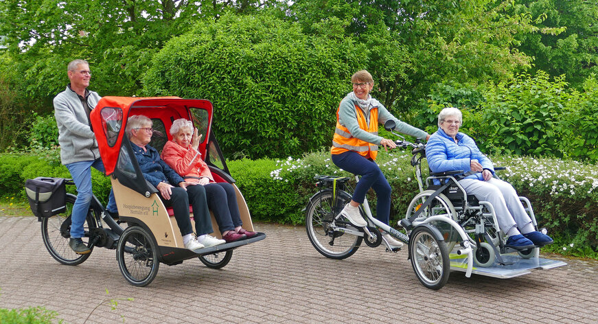 links Rikscha mit Fahrer und zwei Mitfahrerinnen, rechts Das Rolli-Fiets mit Fahererin und einer Person