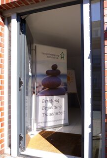 Offene Tür mit Begrüßungsaufsteller